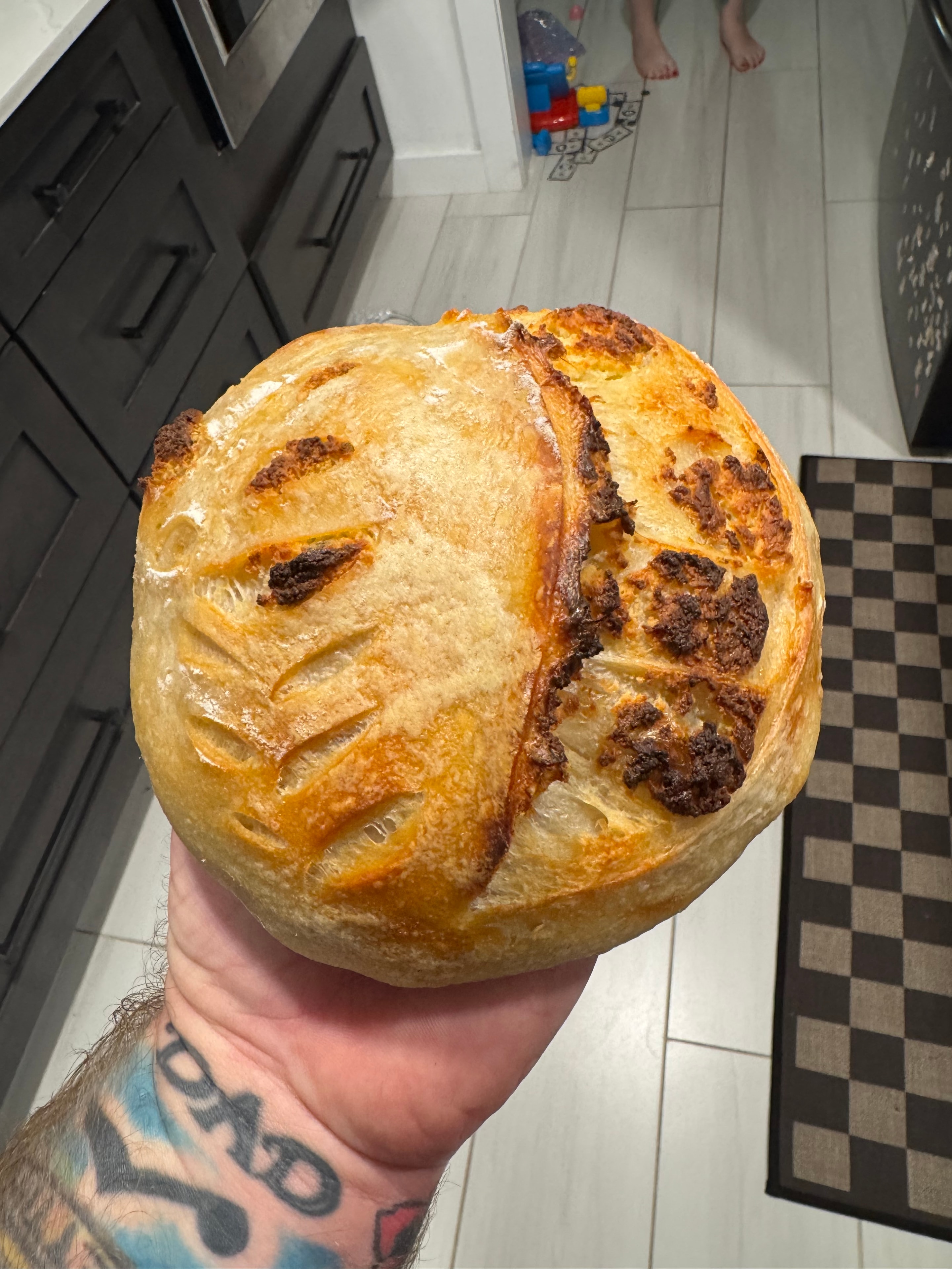 Freshly baked sourdough loaf held up proudly