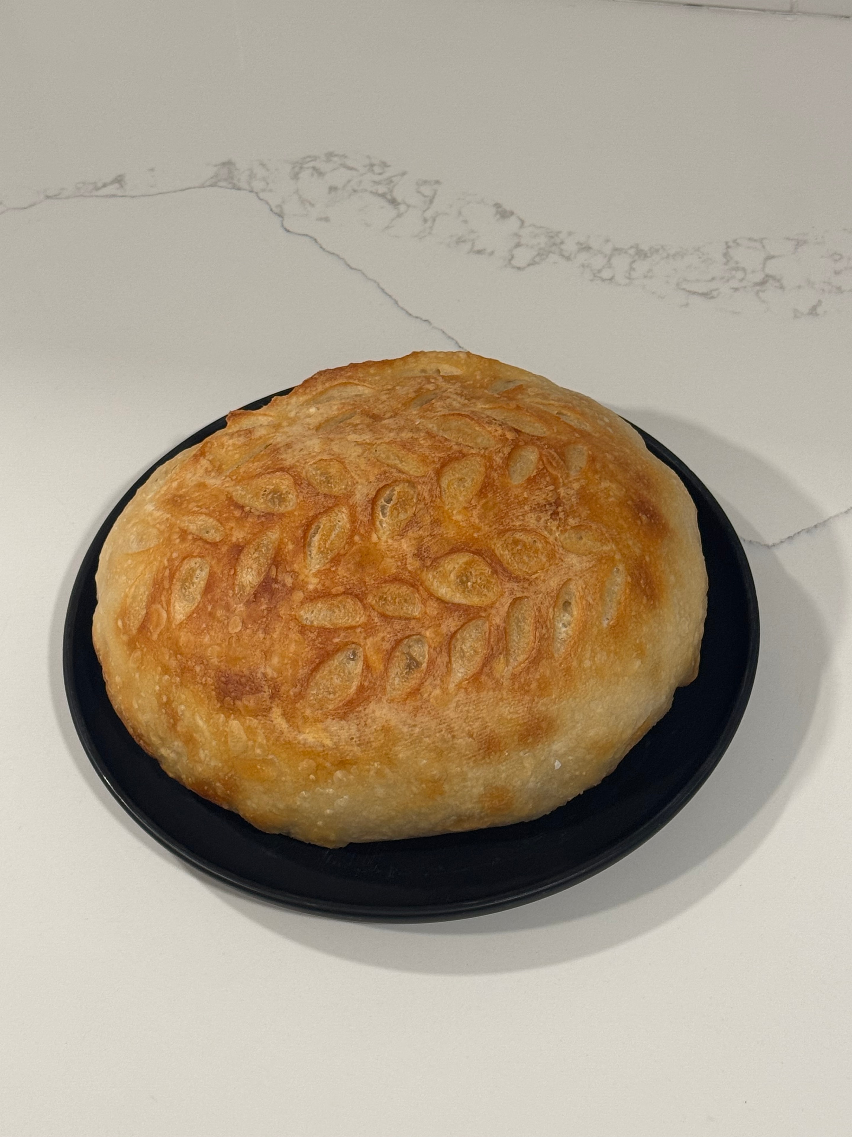 Seeded sourdough loaf in a black pan
